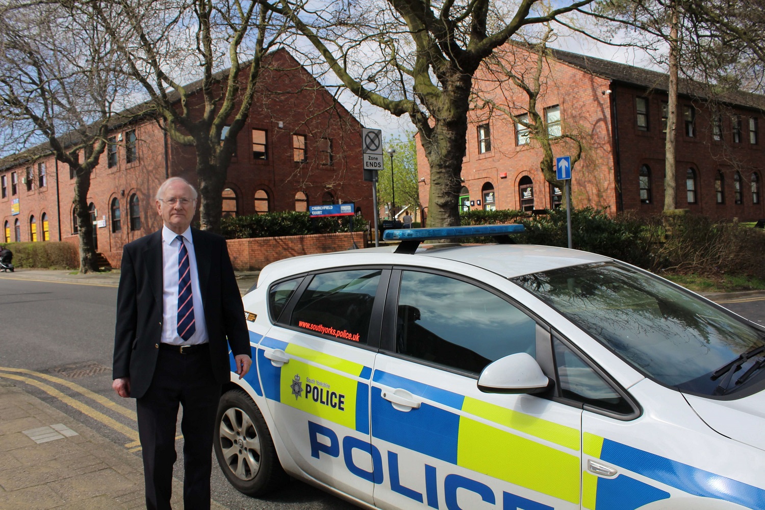 Dr Alan Billings stood next to a Police Car