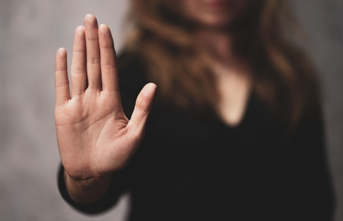A female holds her hand up in a 'stop' gesture